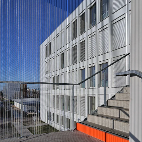 Verkleidung eines außenliegenden Treppenturms mit HAVER Architekturgewebe