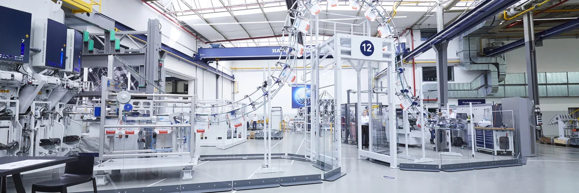 Automated cement packaging line with HAVER & BOECKER PATHFINDER bag transport system in a modern plant, showing efficient empty bag logistics and packaging automation for cement production.